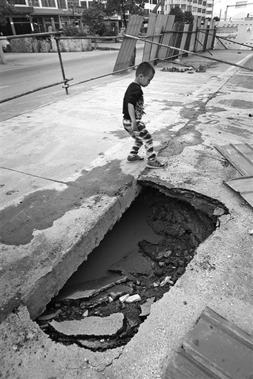 小货车开着开着后轮掉坑里 一看路面下竟是空心